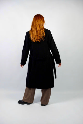 Hochwertiger, schwarzer 00s Wollmantel mit Kaschmir-Anteil – klassisch und elegant geschnitten, mit seitlichen Eingrifftaschen und Bindegürtel – die angegebene Größe ist L, fällt unserer Einschätzung nach kleiner aus; wir empfehlen den Mantel einer M oder S/M (bitte Maße beachten) – ein absolutes Highlight