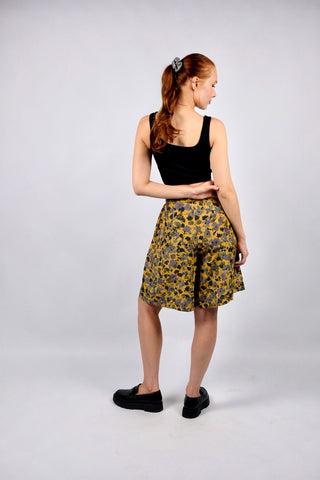 tolle 80s/90s Bermuda-Shorts im Hosenrock-Stil in schönem Senf mit hoher Taille und abstrakt-floralem Muster in gedecktem Grau, Braun, Grün und Lila – luftig leicht und fließender Fall, vermutlich aus reiner Seide gefertigt – ideal für eine heutige S und ein absolutes Highlight