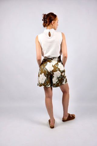 Traumhafte 80s Shorts made in Italy aus Seide (vermutlich handelt es sich um eine hochwertige Duchesse- oder Shantung-/Wildseide) – die Shorts hat einen edlen, matten Glanz und ein florales Muster in tollen Farben (Braun, Weiß, Creme, Greige, Salbei, Hellgrün und Weinrot) sowie klassischen Ultra High Waist Schnitt mit zwei Knöpfen, Bundfalten und seitlichen Eingrifftaschen – ein Signature-Design der gehobenen 80s-Mode, ein seltenes Fundstück und absolutes Highlight in hervorragendem Zustand.
