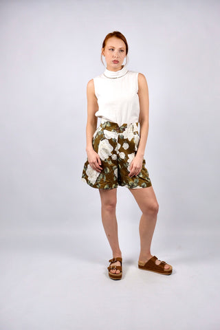 Traumhafte 80s Shorts made in Italy aus Seide (vermutlich handelt es sich um eine hochwertige Duchesse- oder Shantung-/Wildseide) – die Shorts hat einen edlen, matten Glanz und ein florales Muster in tollen Farben (Braun, Weiß, Creme, Greige, Salbei, Hellgrün und Weinrot) sowie klassischen Ultra High Waist Schnitt mit zwei Knöpfen, Bundfalten und seitlichen Eingrifftaschen – ein Signature-Design der gehobenen 80s-Mode, ein seltenes Fundstück und absolutes Highlight in hervorragendem Zustand.