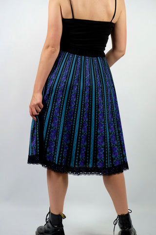 Hochwertiger 70s/80s High Waist Rock aus reiner Baumwolle im Folklore-/Landhaus-Stil, toller Schnitt in A-Linie mit stretchy Gummizugbund, Lochspitze am Saum sowie floralem Streifenmuster in Schwarz, Türkis, Lila, Flieder und Graugrün – ideal für eine L und ein absolutes Highlight