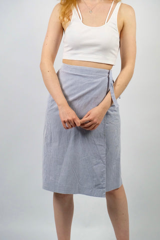 80s High Waist Wickelrock made in France mit zartem Streifenmuster in Blau und Weiß sowie einer seitlichen Eingrifftasche – wir empfehlen den Rock einer L