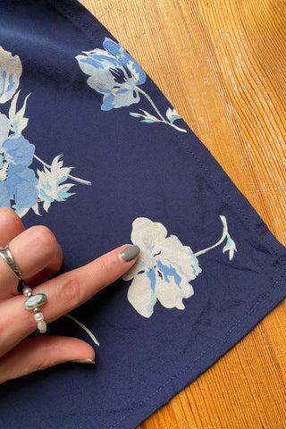 dunkelblauer 90s Viskose Wickelrock mit hoher Taille, kleinen Beinschlitzen und floralem Muster in Hellblau, Graublau, Mint und Cremeweiß – fällt ca. aus wie eine heutige S
