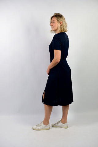 Elegantes, dunkelblaues 80s/90s Kleid made in Italy mit durchgehender Knopfleiste, leichten Schulterpolstern (welche je nach Belieben auch einfach herausgetrennt werden könnten) und Beinschlitzen – die angegebene Größe ist L, fällt unserer Einschätzung nach etwas kleiner aus: wir empfehlen das Kleid einer heutigen M oder der Zwischengröße M/L