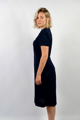 Elegantes, dunkelblaues 80s/90s Kleid made in Italy mit durchgehender Knopfleiste, leichten Schulterpolstern (welche je nach Belieben auch einfach herausgetrennt werden könnten) und Beinschlitzen – die angegebene Größe ist L, fällt unserer Einschätzung nach etwas kleiner aus: wir empfehlen das Kleid einer heutigen M oder der Zwischengröße M/L