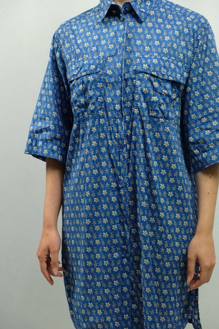 Blaue 90s Longbluse bzw. Blusenkleid aus reiner Baumwolle mit floralem Muster und Seitenschlitzen, die angegebene Größe ist 46, fällt aber eher kleiner aus – und wir empfehlen das Blusenkleid für einen lockeren/oversized Look einer M oder L