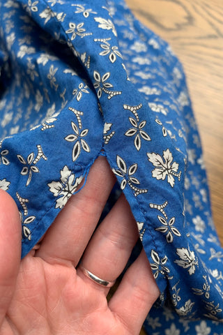 Blaue 90s Longbluse bzw. Blusenkleid aus reiner Baumwolle mit floralem Muster und Seitenschlitzen, die angegebene Größe ist 46, fällt aber eher kleiner aus – und wir empfehlen das Blusenkleid für einen lockeren/oversized Look einer M oder L