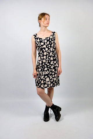 Schwarzes, locker geschnittenes 90s Viskose Kleid made in Italy von der Luxusmarke Pierre Cardin, mit floralem Print in Puderbeige/Creme und zartem Altrosa und am Rücken zum Knoten; wir empfehlen das Kleid einer heutigen M – ein seltenes Fundstück und Marken-Highlight