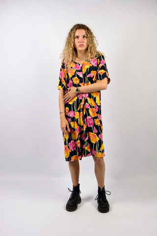 schwarzes 80s Viskose Kleid in lässigem Shirt-/Blusenschnitt mit durchgehender Knopfleiste und Blumenmuster in Pink, Rosa, Orange, Gelb, Weiß und Lindgrün – wir empfehlen das Kleid einer L bis XL