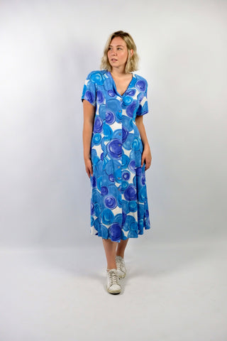 80s/90s Midikleid aus reiner Viskose mit V-Ausschnitt, durchgehender Knopfleiste, Bändchen zum Binden am Rücken und Crazy Pattern Print in Blau, Lilablau, Türkis und Weiß – wir empfehlen das Kleid einer heutigen L
