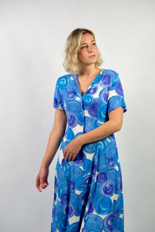 80s/90s Midikleid aus reiner Viskose mit V-Ausschnitt, durchgehender Knopfleiste, Bändchen zum Binden am Rücken und Crazy Pattern Print in Blau, Lilablau, Türkis und Weiß – wir empfehlen das Kleid einer heutigen L