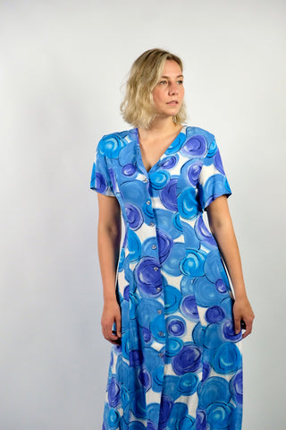 80s/90s Midikleid aus reiner Viskose mit V-Ausschnitt, durchgehender Knopfleiste, Bändchen zum Binden am Rücken und Crazy Pattern Print in Blau, Lilablau, Türkis und Weiß – wir empfehlen das Kleid einer heutigen L