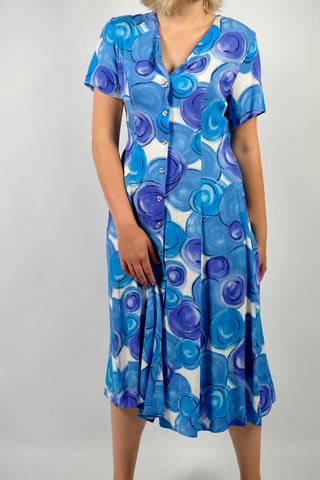 80s/90s Midikleid aus reiner Viskose mit V-Ausschnitt, durchgehender Knopfleiste, Bändchen zum Binden am Rücken und Crazy Pattern Print in Blau, Lilablau, Türkis und Weiß – wir empfehlen das Kleid einer heutigen L