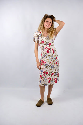 Cremeweißes/meliertes 80s/90s Kleid mit durchgehender Knopfleiste, Bändchen zum Binden am Rücken, Beinschlitzen und tollem Blumenmuster in Rot, Blau, Gelb und Grünbraun – es sind leichte Schulterpolster vorhanden, welche je nach Belieben aber auch ganz einfach herausgetrennt werden könnten – ideal für eine heutige S bis M und ein absolutes Highlight