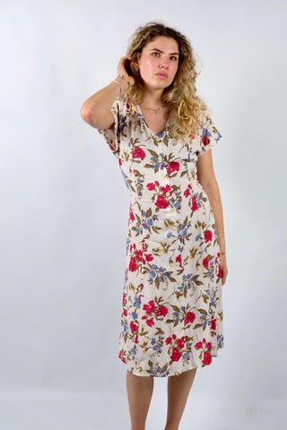 Cremeweißes/meliertes 80s/90s Kleid mit durchgehender Knopfleiste, Bändchen zum Binden am Rücken, Beinschlitzen und tollem Blumenmuster in Rot, Blau, Gelb und Grünbraun – es sind leichte Schulterpolster vorhanden, welche je nach Belieben aber auch ganz einfach herausgetrennt werden könnten – ideal für eine heutige S bis M und ein absolutes Highlight