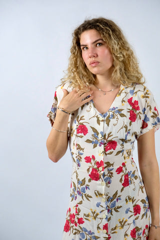 Cremeweißes/meliertes 80s/90s Kleid mit durchgehender Knopfleiste, Bändchen zum Binden am Rücken, Beinschlitzen und tollem Blumenmuster in Rot, Blau, Gelb und Grünbraun – es sind leichte Schulterpolster vorhanden, welche je nach Belieben aber auch ganz einfach herausgetrennt werden könnten – ideal für eine heutige S bis M und ein absolutes Highlight