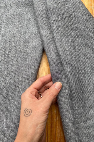 Grau meliertes Preloved (Secondhand) Herbstkleid aus einer Boutique, weicher Strickstoff und lässiger Schnitt mit aufgesetzten Taschen und Fransen – tragbar von einer S bis M