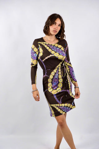 Dunkelbraunes 70s Boho Langarmkleid in figurbetontem Schnitt mit Bindegürtel und tollem floralem Print in Gelb, Flieder, Lila, (Creme)weiß, Orange und Blau – insgesamt leicht elastisch, tragbar von einer XS bis S je nach gewünschter Passform und ein absolutes Highlight