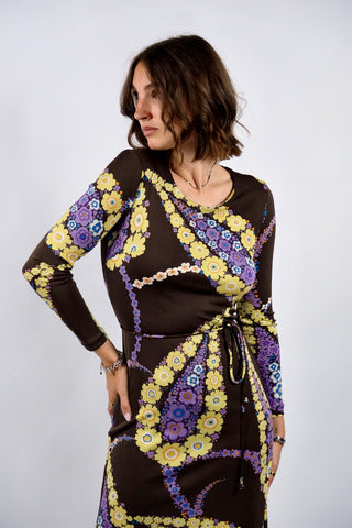 Dunkelbraunes 70s Boho Langarmkleid in figurbetontem Schnitt mit Bindegürtel und tollem floralem Print in Gelb, Flieder, Lila, (Creme)weiß, Orange und Blau – insgesamt leicht elastisch, tragbar von einer XS bis S je nach gewünschter Passform und ein absolutes Highlight
