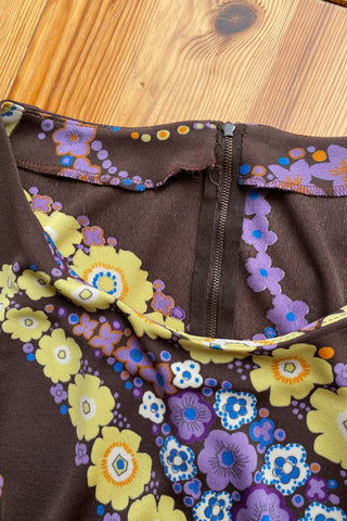 Dunkelbraunes 70s Boho Langarmkleid in figurbetontem Schnitt mit Bindegürtel und tollem floralem Print in Gelb, Flieder, Lila, (Creme)weiß, Orange und Blau – insgesamt leicht elastisch, tragbar von einer XS bis S je nach gewünschter Passform und ein absolutes Highlight