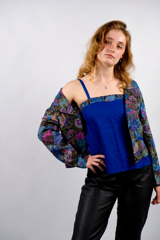 80s Zweiteiler bestehend aus einem Blazer mit abstrakt-floralem Crazy Pattern Print in Blautönen, Braun, Schwarz, Pink und Mint sowie dazu passendem Trägertop in Royalblau, ebenfalls dezent am Ausschnitt gemustert – das Set besteht aus angenehmer Materialmischung (Baumwolle-Modal) und ist für eine heutige XS bis S zu empfehlen (bitte Anmerkung beachten)