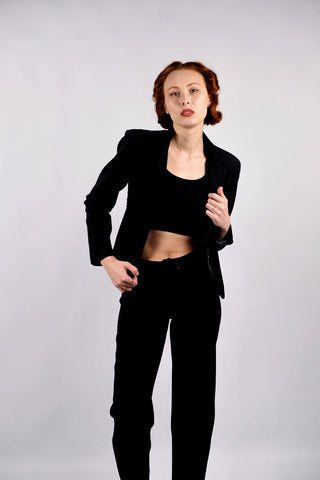 Atemberaubender 90s/00s Hosenanzug aus schwarzer Viskose und Schurwolle; das Set besteht aus einem taillierten, klassischen Blazer sowie einer dazu passenden Mid Waist Hose mit geradem Bein – außerdem hat der Zweiteiler dezente, geschnürte Kunstleder-Details – ein seltenes Fundstück und absolutes Highlight in Größe S