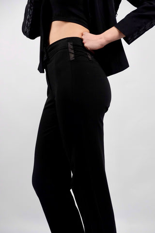 Atemberaubender 90s/00s Hosenanzug aus schwarzer Viskose und Schurwolle; das Set besteht aus einem taillierten, klassischen Blazer sowie einer dazu passenden Mid Waist Hose mit geradem Bein – außerdem hat der Zweiteiler dezente, geschnürte Kunstleder-Details – ein seltenes Fundstück und absolutes Highlight in Größe S