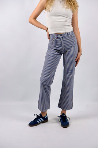 Blau-Weiß gestreifte 90s Hose aus reiner Baumwolle mit Mid Waist Bundhöhe und unten leicht ausgestelltem Bein sowie floralem Mickey Mouse Design auf den hinteren Hosentaschen – ein absolutes Highlight und passend für eine heutige XXS
