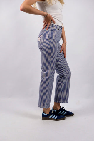 Blau-Weiß gestreifte 90s Hose aus reiner Baumwolle mit Mid Waist Bundhöhe und unten leicht ausgestelltem Bein sowie floralem Mickey Mouse Design auf den hinteren Hosentaschen – ein absolutes Highlight und passend für eine heutige XXS