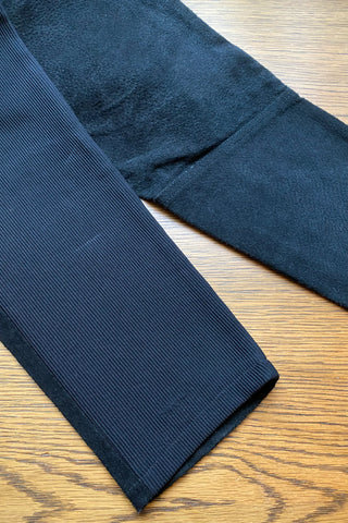 schwarze 80s High Waist Hose mit Vorderteil aus Veloursleder und hinten aus geripptem Stretch-Stoff, toller Reithosenstil und integrierter Gürtel – da es keinen Reißverschluss zur Einstiegshilfe gibt, empfehlen wir die Hose einer heutigen XS – ein seltenes Fundstück und absolutes Highlight