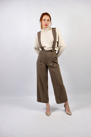 Atemberaubende 90s Marlenehose made in U.K. in einem tollen Oliv/Taupe, mit seitlichen Knöpfen, Eingrifftaschen, abnehmbaren Hosenträgern und weitem Bein – wir empfehlen die Hose einer XS – ein seltenes Fundstück und absolutes Highlight