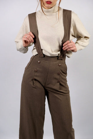 Atemberaubende 90s Marlenehose made in U.K. in einem tollen Oliv/Taupe, mit seitlichen Knöpfen, Eingrifftaschen, abnehmbaren Hosenträgern und weitem Bein – wir empfehlen die Hose einer XS – ein seltenes Fundstück und absolutes Highlight