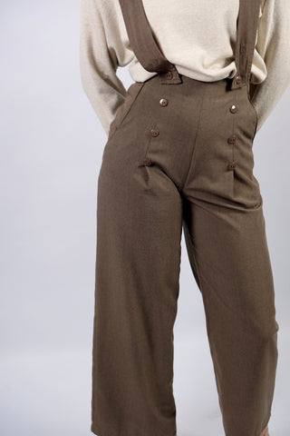 Atemberaubende 90s Marlenehose made in U.K. in einem tollen Oliv/Taupe, mit seitlichen Knöpfen, Eingrifftaschen, abnehmbaren Hosenträgern und weitem Bein – wir empfehlen die Hose einer XS – ein seltenes Fundstück und absolutes Highlight