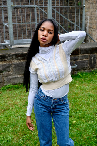 80s/90s Pullunder/Stricktop made in France mit V-Ausschnitt vorn und am Rücken, hübschem Zopfstrickmuster und Knopfdetails hinten; die Farbe ist ein tolles Vanillegelb/Beige und Weiß, der Pullunder ist cropped geschnitten und ideal für eine XS – ein absolutes Highlight