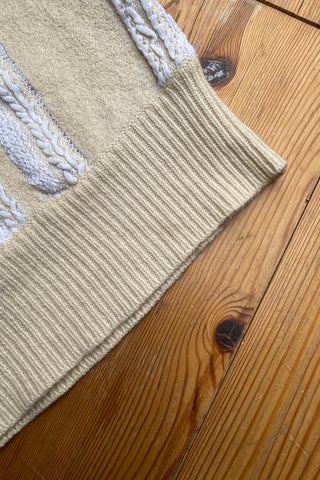 80s/90s Pullunder/Stricktop made in France mit V-Ausschnitt vorn und am Rücken, hübschem Zopfstrickmuster und Knopfdetails hinten; die Farbe ist ein tolles Vanillegelb/Beige und Weiß, der Pullunder ist cropped geschnitten und ideal für eine XS – ein absolutes Highlight