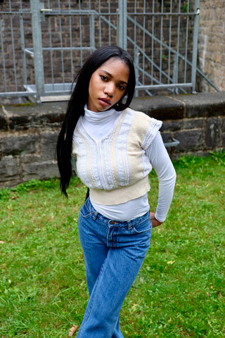 80s/90s Pullunder/Stricktop made in France mit V-Ausschnitt vorn und am Rücken, hübschem Zopfstrickmuster und Knopfdetails hinten; die Farbe ist ein tolles Vanillegelb/Beige und Weiß, der Pullunder ist cropped geschnitten und ideal für eine XS – ein absolutes Highlight