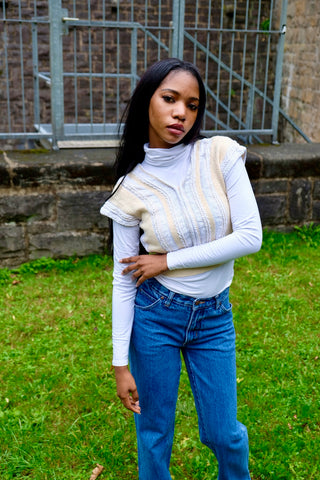 80s/90s Pullunder/Stricktop made in France mit V-Ausschnitt vorn und am Rücken, hübschem Zopfstrickmuster und Knopfdetails hinten; die Farbe ist ein tolles Vanillegelb/Beige und Weiß, der Pullunder ist cropped geschnitten und ideal für eine XS – ein absolutes Highlight