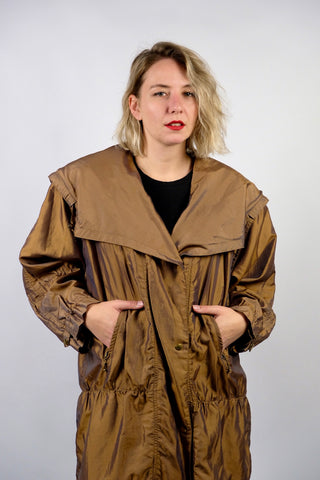 Leichter 80s/90s Parka in bewusst lockerem Schnitt mit extra großem Kragen und seitlichen Eingrifftaschen, die Farbe würden wir als ein tolles Olivgold oder Goldbraun beschreiben – wir empfehlen den Parka einer XXL – ein absolutes Highlight