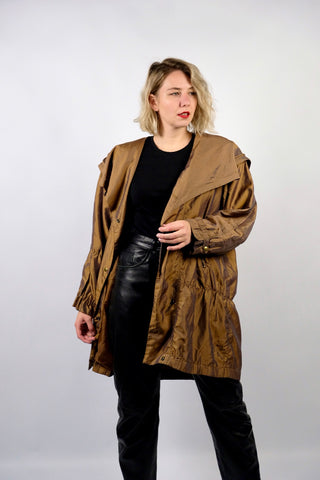 Leichter 80s/90s Parka in bewusst lockerem Schnitt mit extra großem Kragen und seitlichen Eingrifftaschen, die Farbe würden wir als ein tolles Olivgold oder Goldbraun beschreiben – wir empfehlen den Parka einer XXL – ein absolutes Highlight
