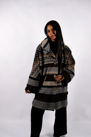 90s Mantel made in Germany aus Wollmischung mit ethnischem/geometrischem Aztekenmuster in Dunkelbraun, Dunkelgrau/Anthrazit/, Hellgrau, Grau und Graubraun – bewusst sehr oversized/locker geschnittene Größe S, weshalb der Mantel auch noch von einer M und L tragbar ist – ein absolutes Highlight