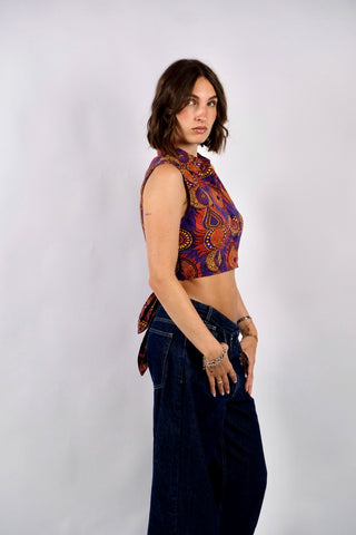 Ärmellose Y2k Baumwollbluse in bauchfreiem Schnitt zum Binden – kann entweder vorne oder hinten geknotet werden – mit tollem Boho Print in Lila, Orangerot, Gelb und Schwarz. Die angegebene Größe ist S, fällt eher klein aus: wir empfehlen die Bluse einer XS oder der Zwischengröße XS/S – ein absolutes Highlight