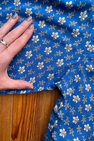 Blaue 80s/90s Bluse aus reiner, leichter Baumwolle mit halblangen Ärmeln und Blümchenmuster in (Creme)weiß – von uns gecropped – entspricht nun ca. einer heutigen M, eignet sich aber auch für oversized Looks an kleineren Größen