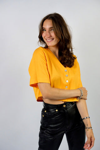 80s Basic Bluse aus Viskosemischung mit V-Ausschnitt – von uns gecropped – die Farbe ist ein tolles, leuchtendes und gelbliches Orange – wir empfehlen die Bluse einer heutigen M