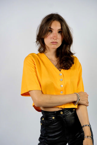 80s Basic Bluse aus Viskosemischung mit V-Ausschnitt – von uns gecropped – die Farbe ist ein tolles, leuchtendes und gelbliches Orange – wir empfehlen die Bluse einer heutigen M