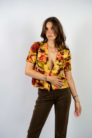 Handmade 80s/90s Bluse in kurzem Schnitt mit tiefem V-Kragen, Hakenverschlüssen mit Zierschleifen sowie floralem Crazy Pattern Print in Rotbraun, Braun, Beige, Weinrot, Orange/Pfirsich, Gelb, Gelbgrün und Hellgrün – wir empfehlen die Bluse einer S – ein Unikat und Highlight