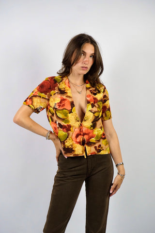 Handmade 80s/90s Bluse in kurzem Schnitt mit tiefem V-Kragen, Hakenverschlüssen mit Zierschleifen sowie floralem Crazy Pattern Print in Rotbraun, Braun, Beige, Weinrot, Orange/Pfirsich, Gelb, Gelbgrün und Hellgrün – wir empfehlen die Bluse einer S – ein Unikat und Highlight