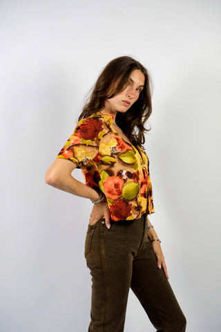 Handmade 80s/90s Bluse in kurzem Schnitt mit tiefem V-Kragen, Hakenverschlüssen mit Zierschleifen sowie floralem Crazy Pattern Print in Rotbraun, Braun, Beige, Weinrot, Orange/Pfirsich, Gelb, Gelbgrün und Hellgrün – wir empfehlen die Bluse einer S – ein Unikat und Highlight
