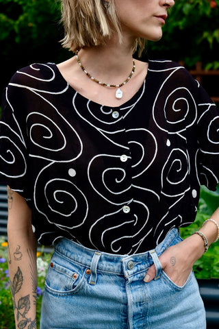 Schwarze, halbtransparente 90s Bluse aus reiner Viskose mit weißem Spiralen-Print – zu empfehlen für eine heutige M bis L