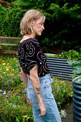 Schwarze, halbtransparente 90s Bluse aus reiner Viskose mit weißem Spiralen-Print – zu empfehlen für eine heutige M bis L