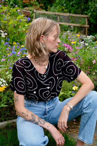 Schwarze, halbtransparente 90s Bluse aus reiner Viskose mit weißem Spiralen-Print – zu empfehlen für eine heutige M bis L